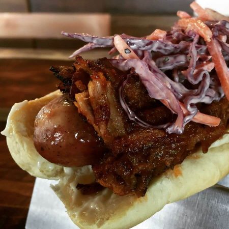 BBQ Pork Dog with house made slow roasted shredded pork, lightly tossed with BBQ and our house coleslaw