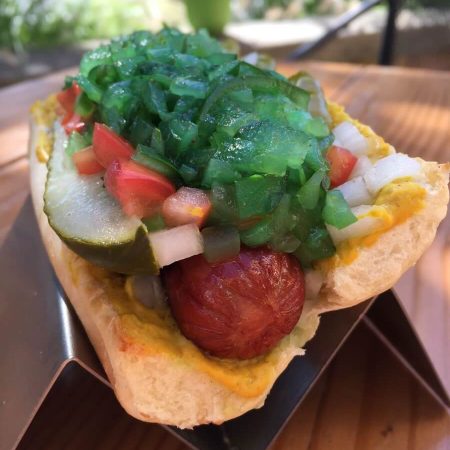 Chicago Dog Chicago dog with mustard, pickle spear, sweet relish, sport peppers, onion, tomato, and celery salt